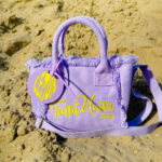 Borsa tintaUNITA Juice limone lilla con clip profumata sulla spiaggia